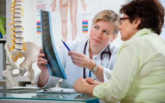 Doctor reviewing a spine X-ray with a patient