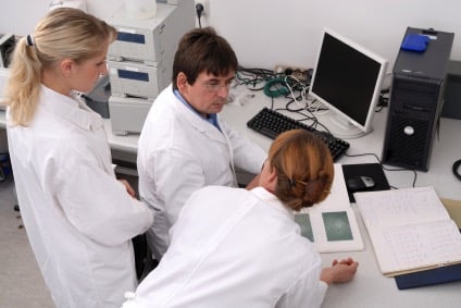 Scientists looking at computer monitor